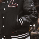 Black letterman jacket with wool body and leather sleeves.