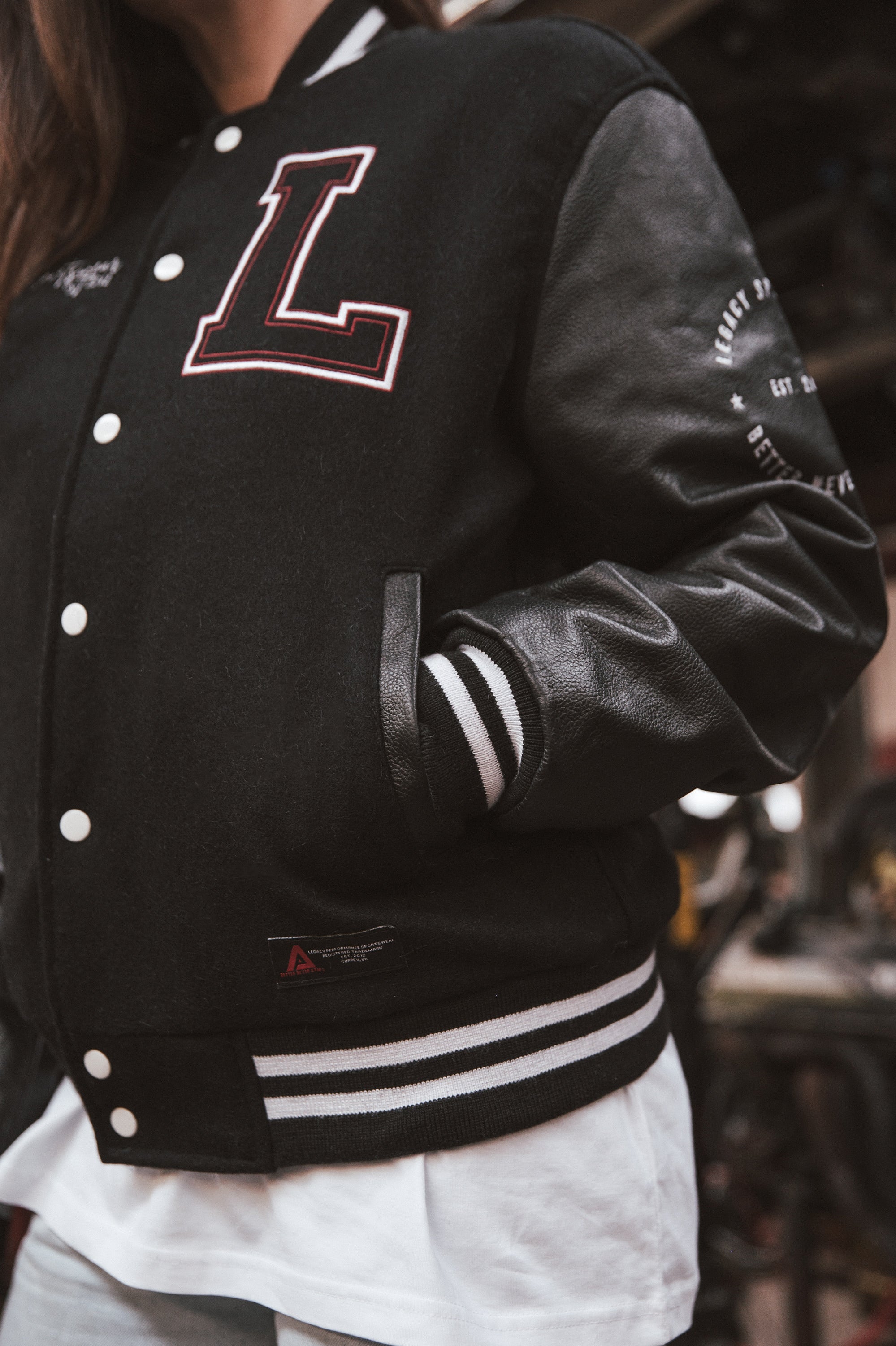 Black letterman jacket with wool body and leather sleeves.