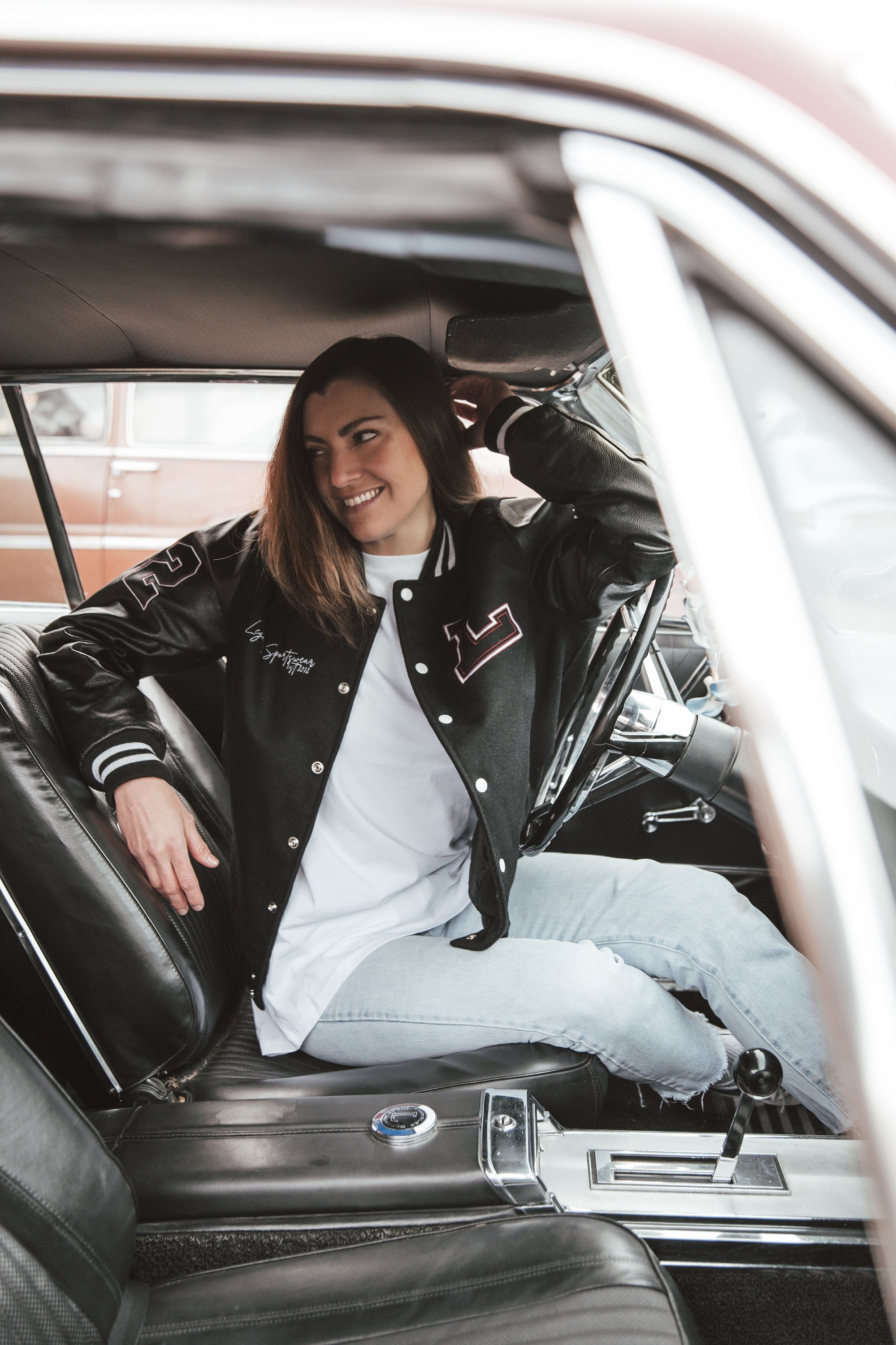 Black letterman jacket with wool body and leather sleeves.