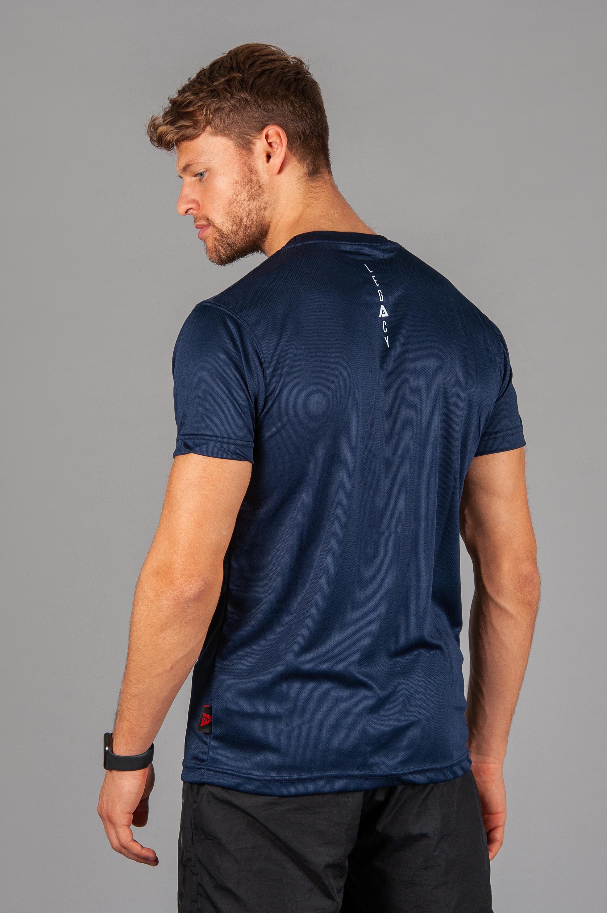 Back view of men's navy moisture wicking crewneck t-shirt with white logo.