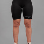 Women's black bike shorts with small white Legacy logo on the leg.
