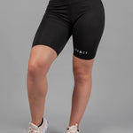 Women's black bike shorts with small white Legacy logo on the leg.