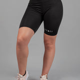 Women's black bike shorts with small white Legacy logo on the leg.
