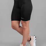 Women's black bike shorts with small white Legacy logo on the leg.