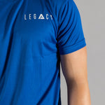 Close up of white logo on men's blue moisture wicking crewneck t-shirt.