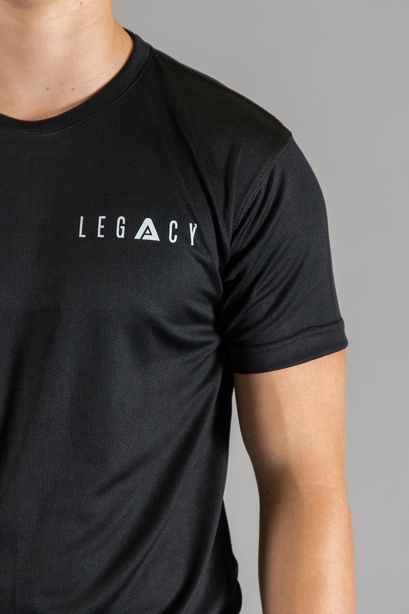 Close up of white logo on men's black moisture wicking crewneck t-shirt.