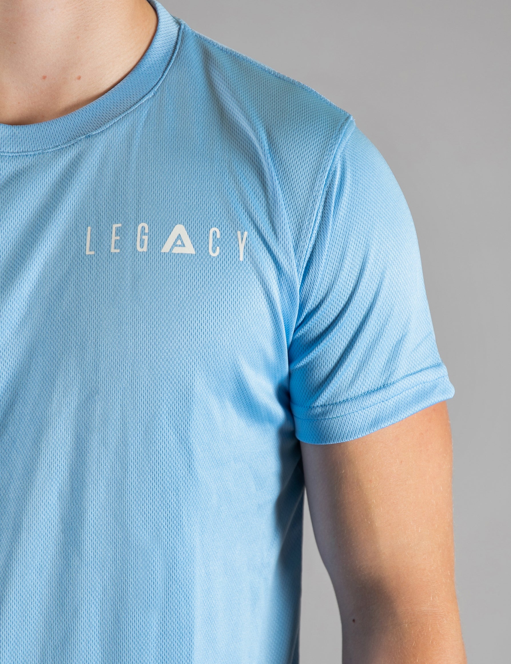 Close up of white logo on men's sky blue moisture wicking crewneck t-shirt.