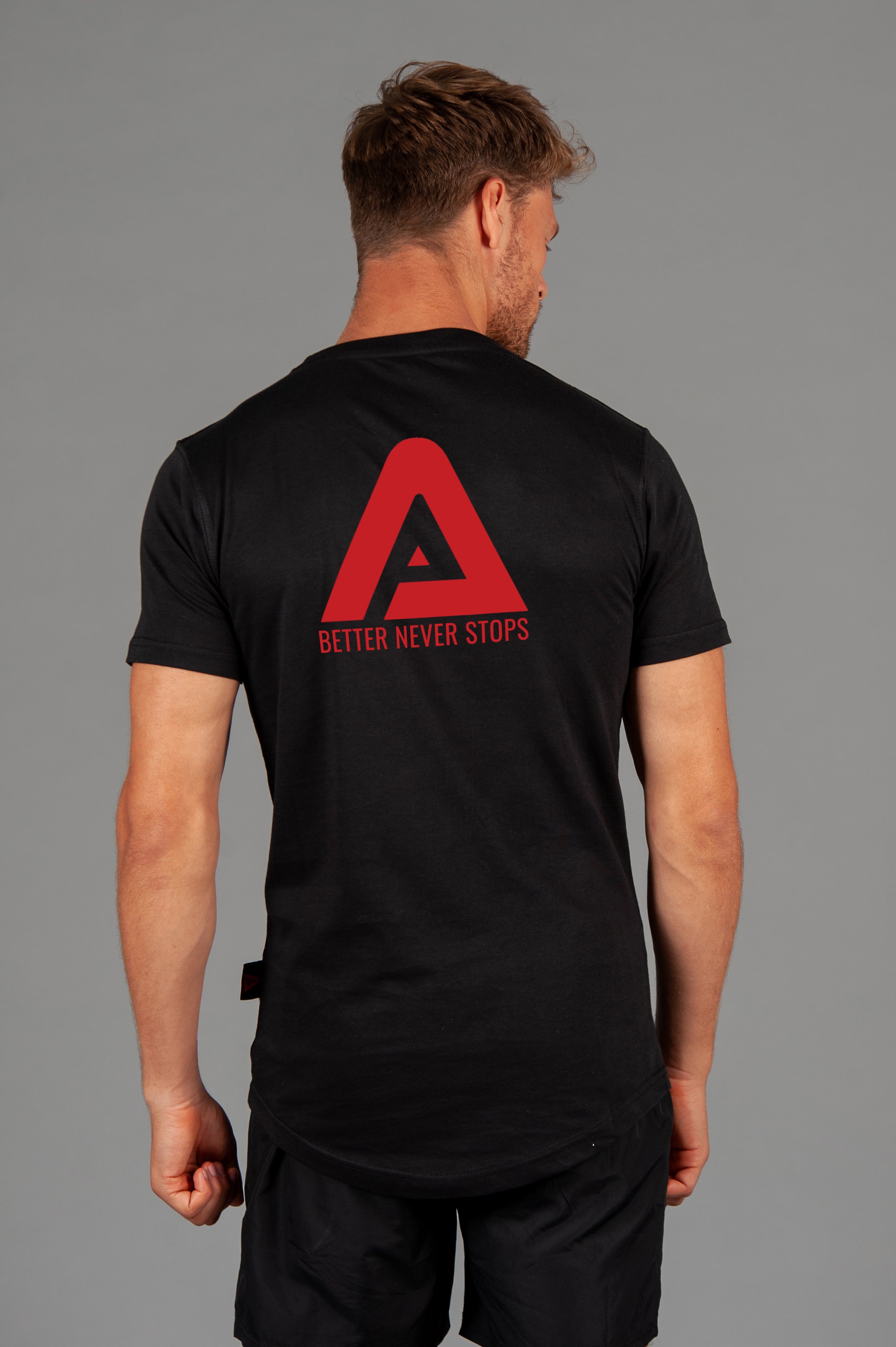 Back view of men's black t-shirt with red Better Never Stops logo. 