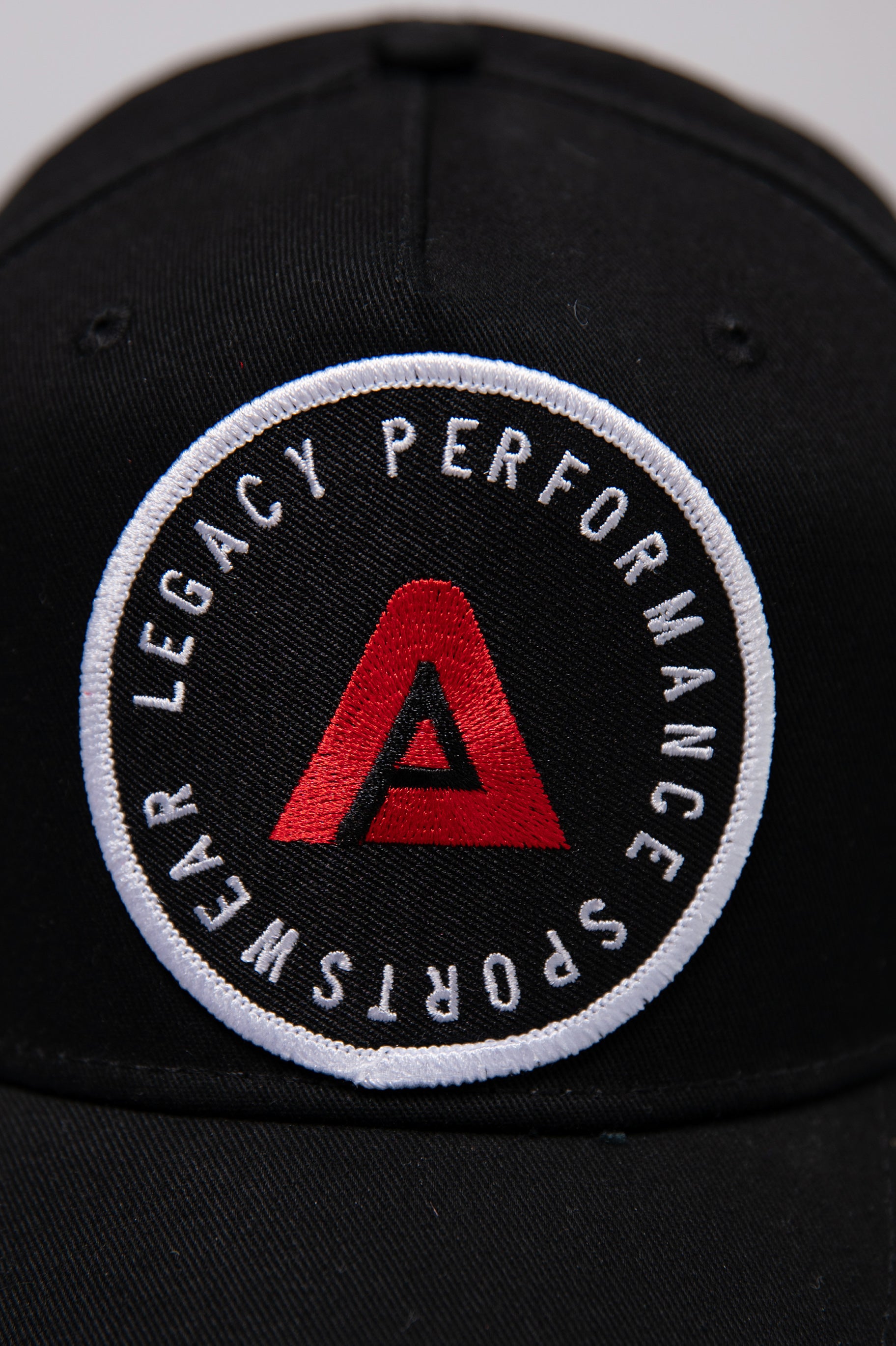 Black Legacy baseball cap with white and red logo. 