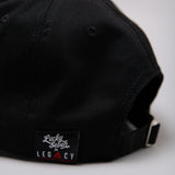 Close up of black Legacy x Lucky Seven baseball cap tag.