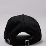 Snapback closure on black Legacy baseball cap with white and red logo. 