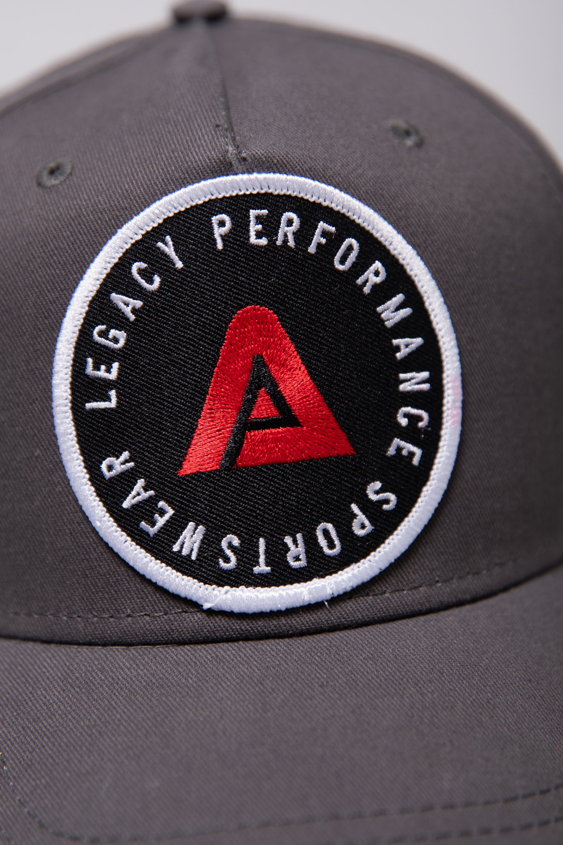 Grey Legacy baseball cap with white, red and black logo.