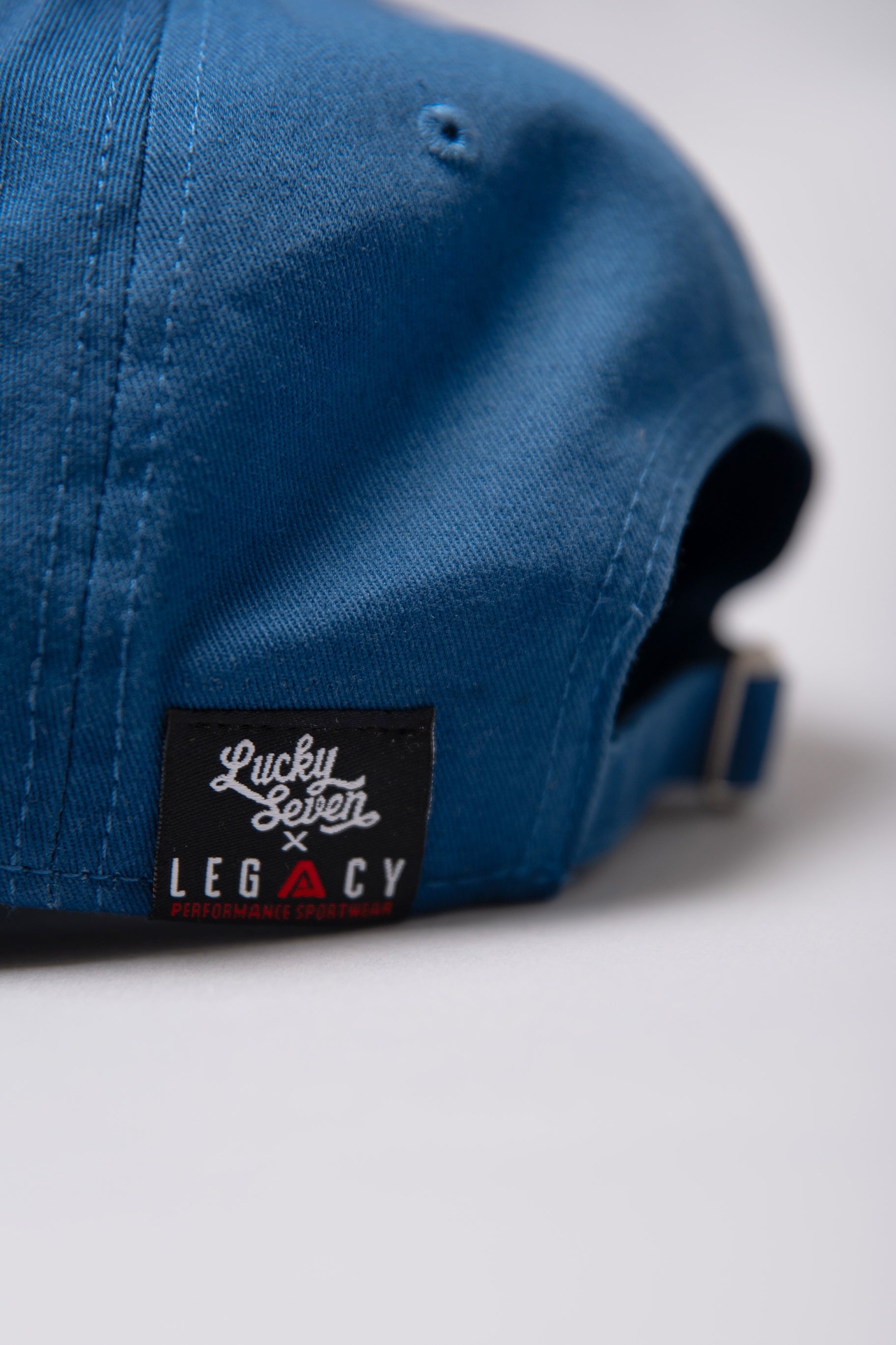 Close up of Legacy x Lucky Seven tag on navy baseball cap.