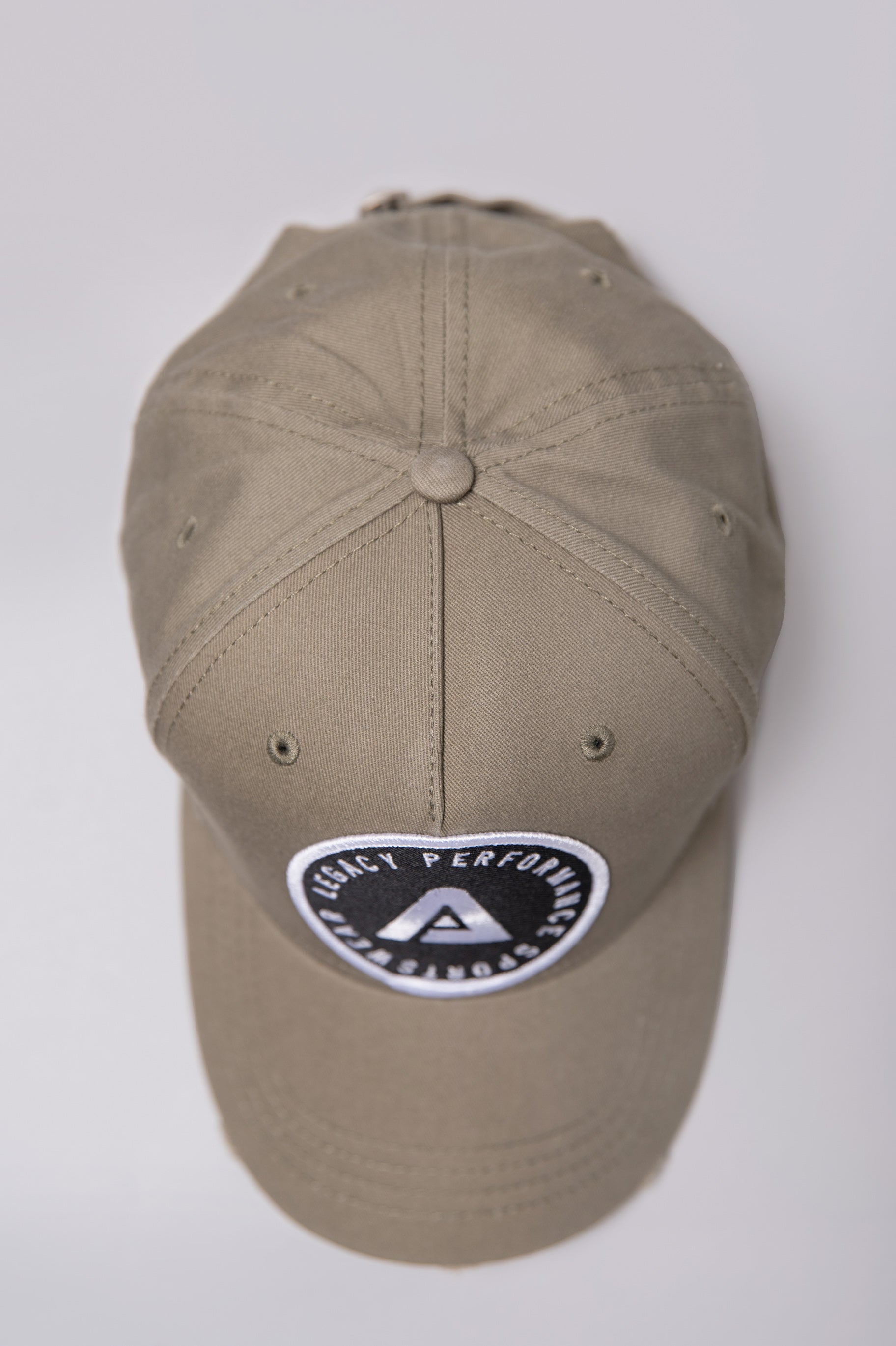 Khaki Legacy baseball cap with black and white logo.