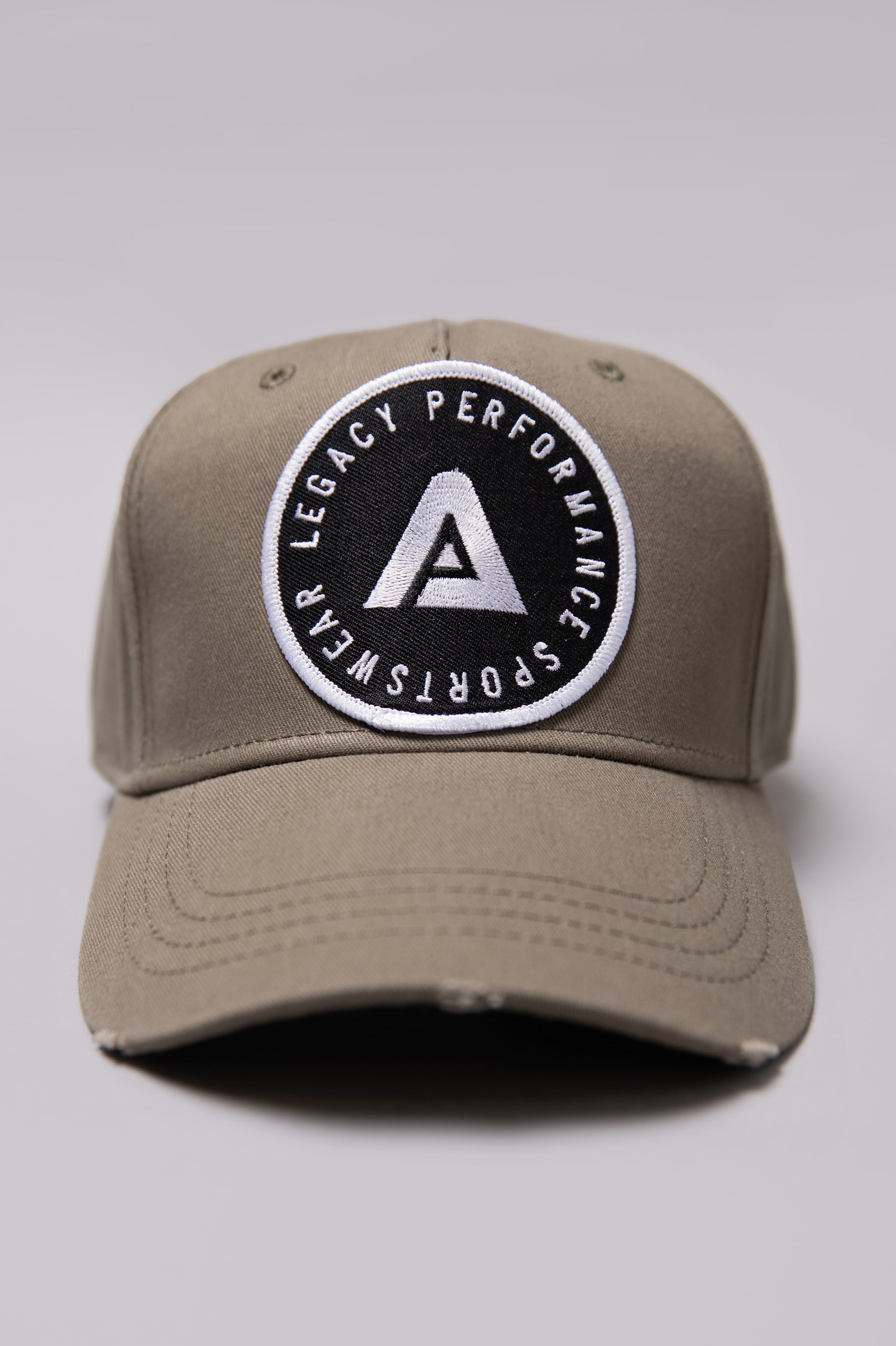 Khaki Legacy baseball cap with black and white logo.