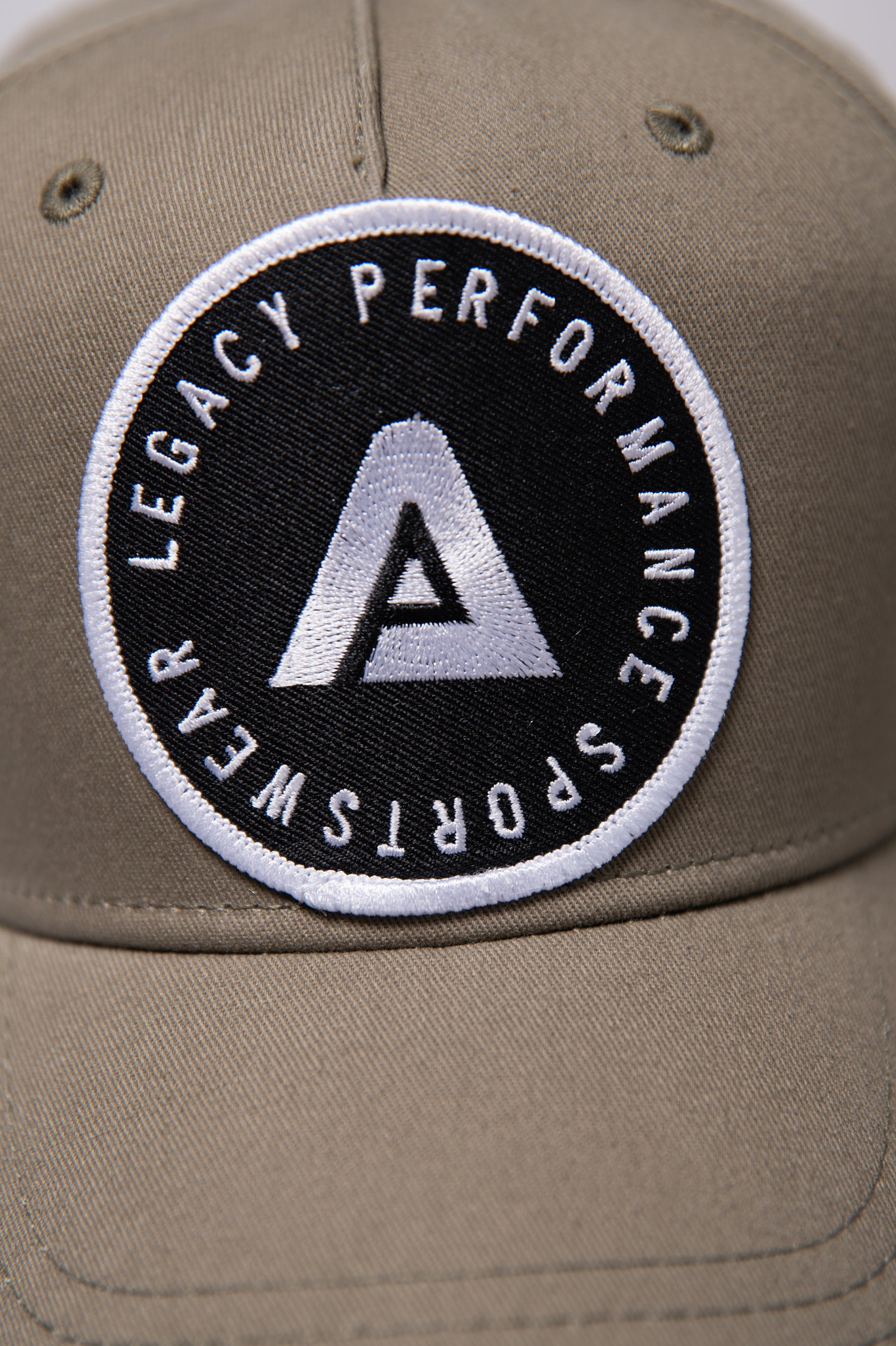 Khaki Legacy baseball cap with black and white logo.