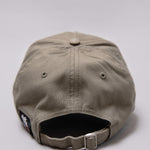 Snapback closure on khaki Legacy baseball cap with black and white logo.