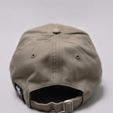 Snapback closure on khaki Legacy baseball cap with black and white logo.