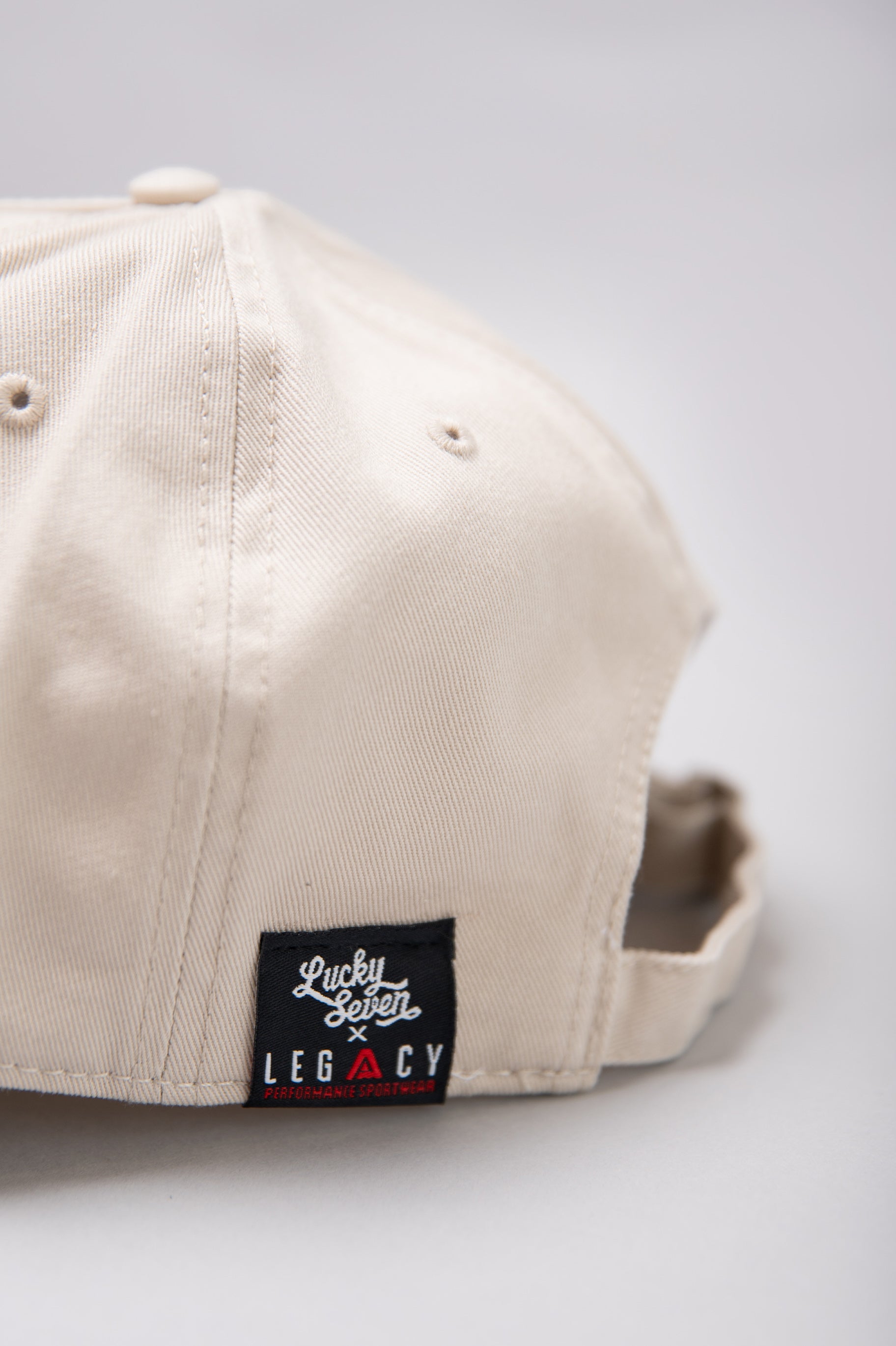 Close up of Legacy x Lucky Seven tag on stone baseball cap.