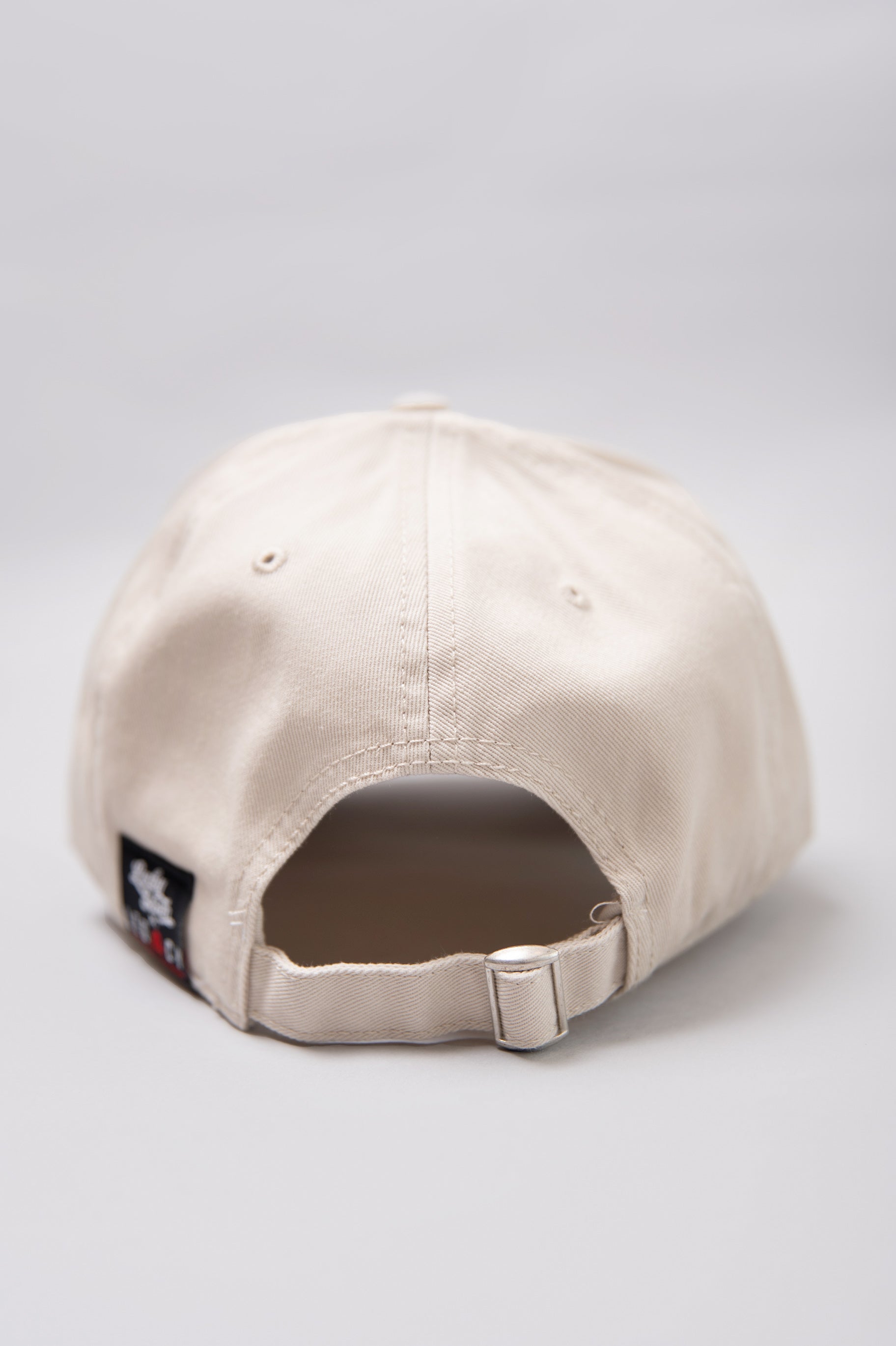 Snapback closure on stone Legacy baseball cap with black, white and red logo.