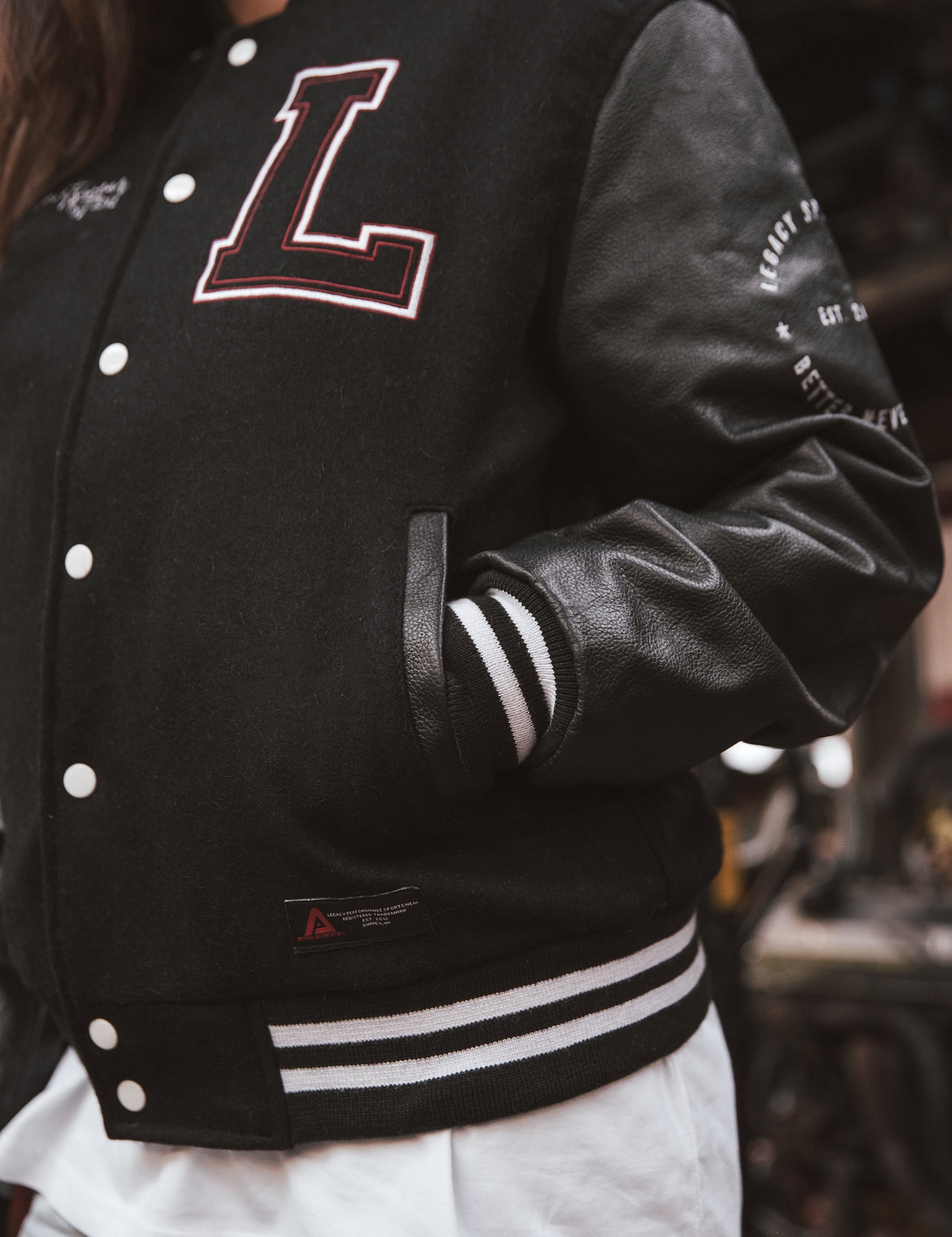 Black letterman jacket with wool body and leather sleeves.