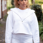 Women's white 1/4 zip cropped hoodie with small black logo.