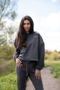 Women's graphite oversized crop hoodie with tie waist and small white logo.