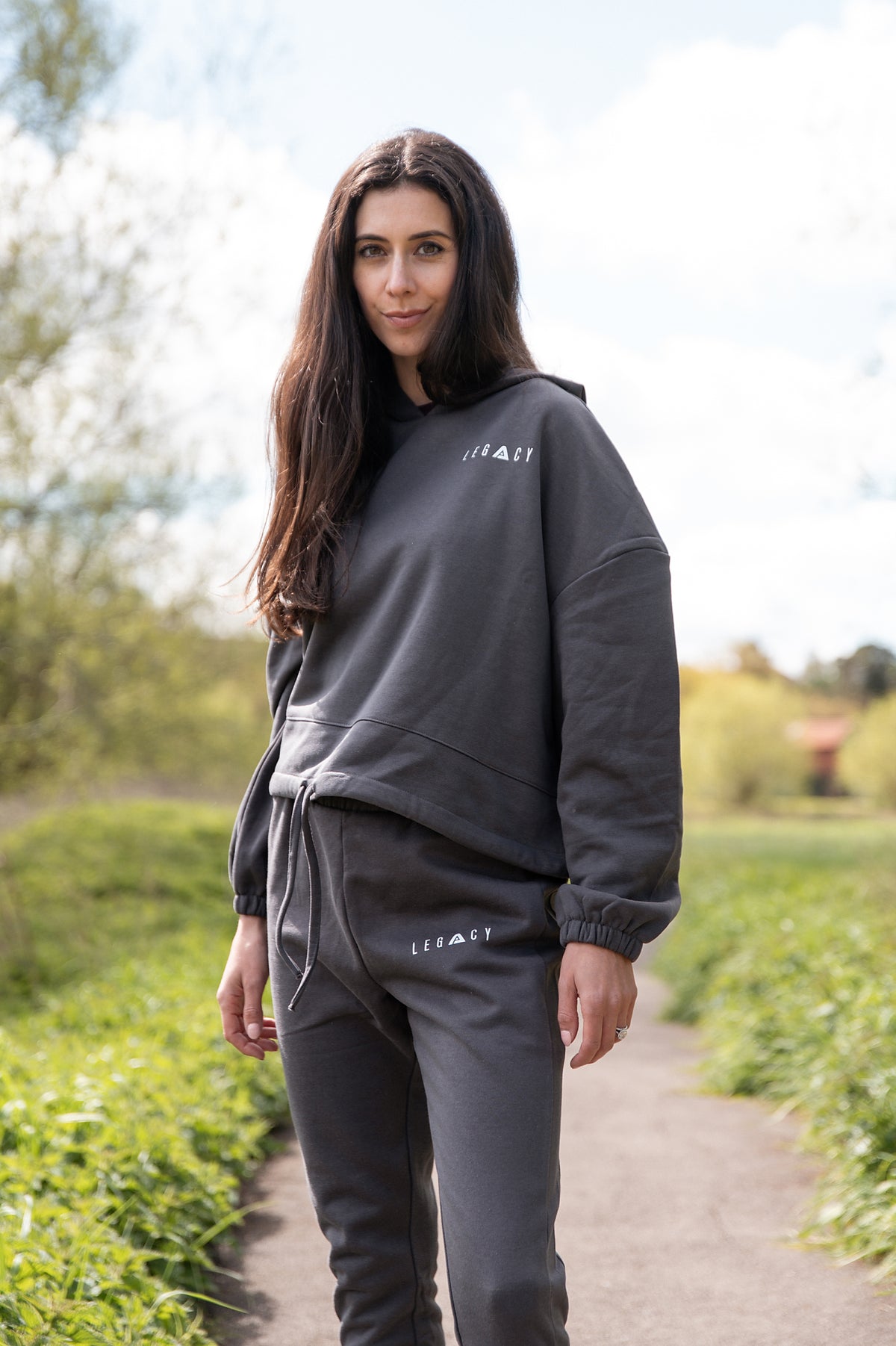 Women's graphite oversized crop hoodie with tie waist and small white logo.