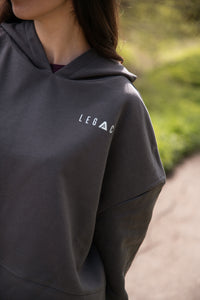 Women's graphite oversized crop hoodie with tie waist and small white logo.