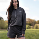 Women's graphite 1/4 zip cropped hoodie with small white logo.