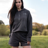 Women's graphite 1/4 zip cropped hoodie with small white logo.