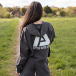 Back view of women's graphite cropped hoodie with white Better Never Stops logo.