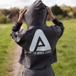 Back view of women's graphite cropped hoodie with white Better Never Stops logo.