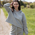 Women's grey oversized crop hoodie with tie waist and small black logo.