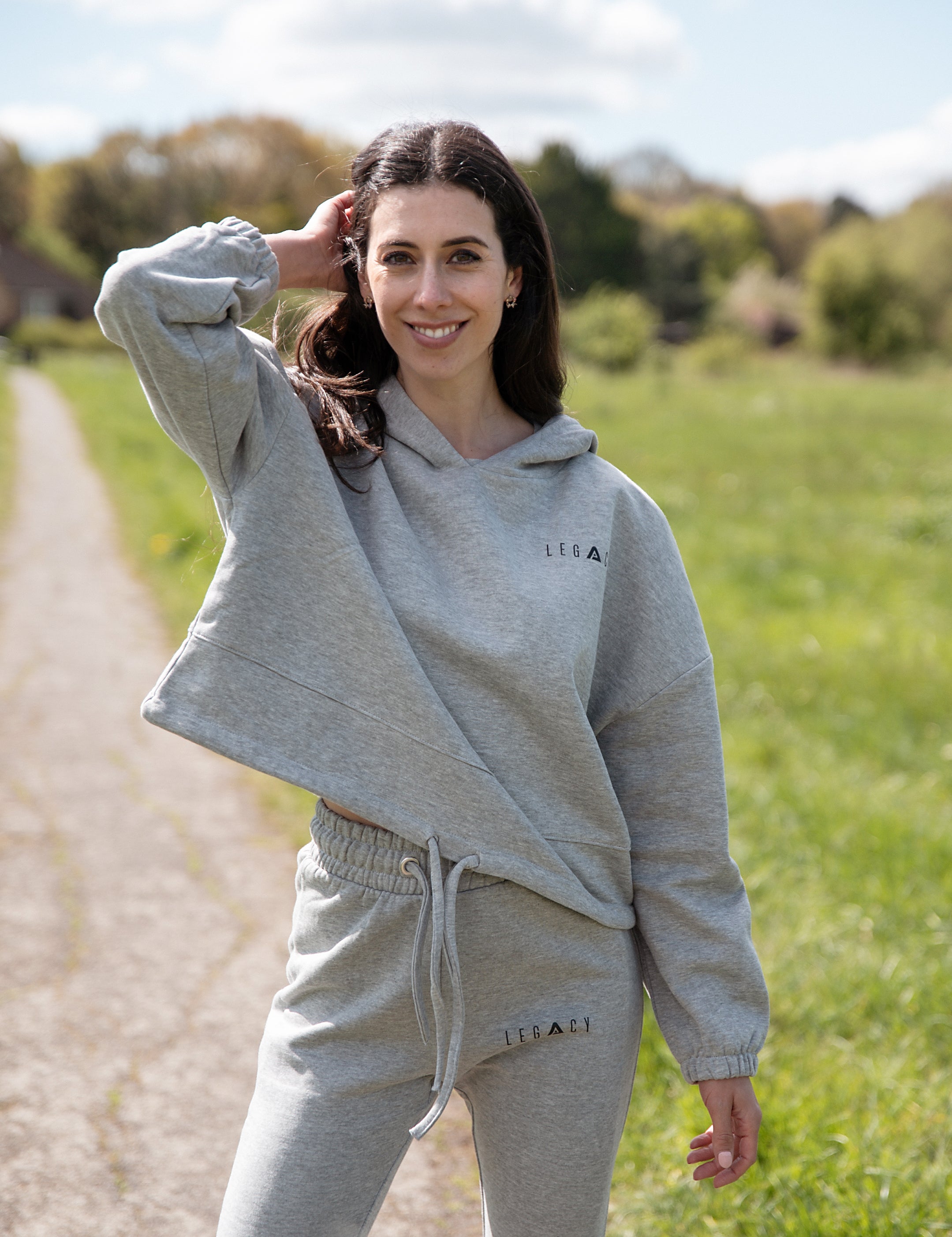 Women's grey oversized crop hoodie with tie waist and small black logo.
