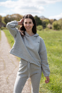 Women's grey oversized crop hoodie with tie waist and small black logo.