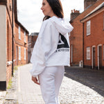 Back view of women's white oversized crop hoodie with tie waist and black Better Never Stops logo.