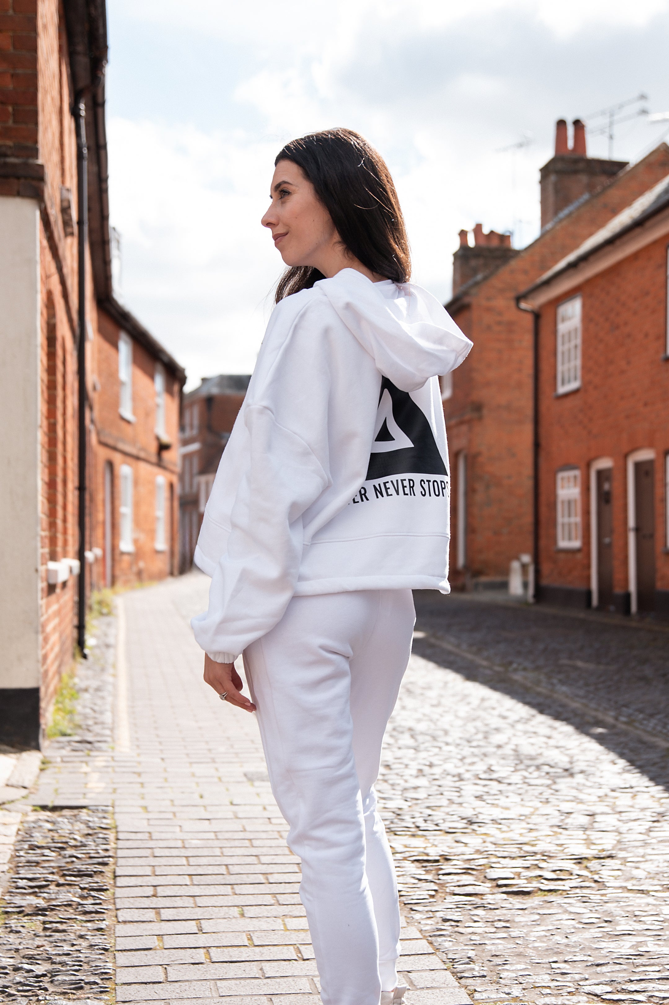 Back view of women's white oversized crop hoodie with tie waist and black Better Never Stops logo.