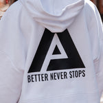 Back view of women's white oversized crop hoodie with tie waist and black Better Never Stops logo.