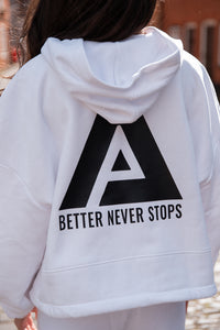 Back view of women's white oversized crop hoodie with tie waist and black Better Never Stops logo.