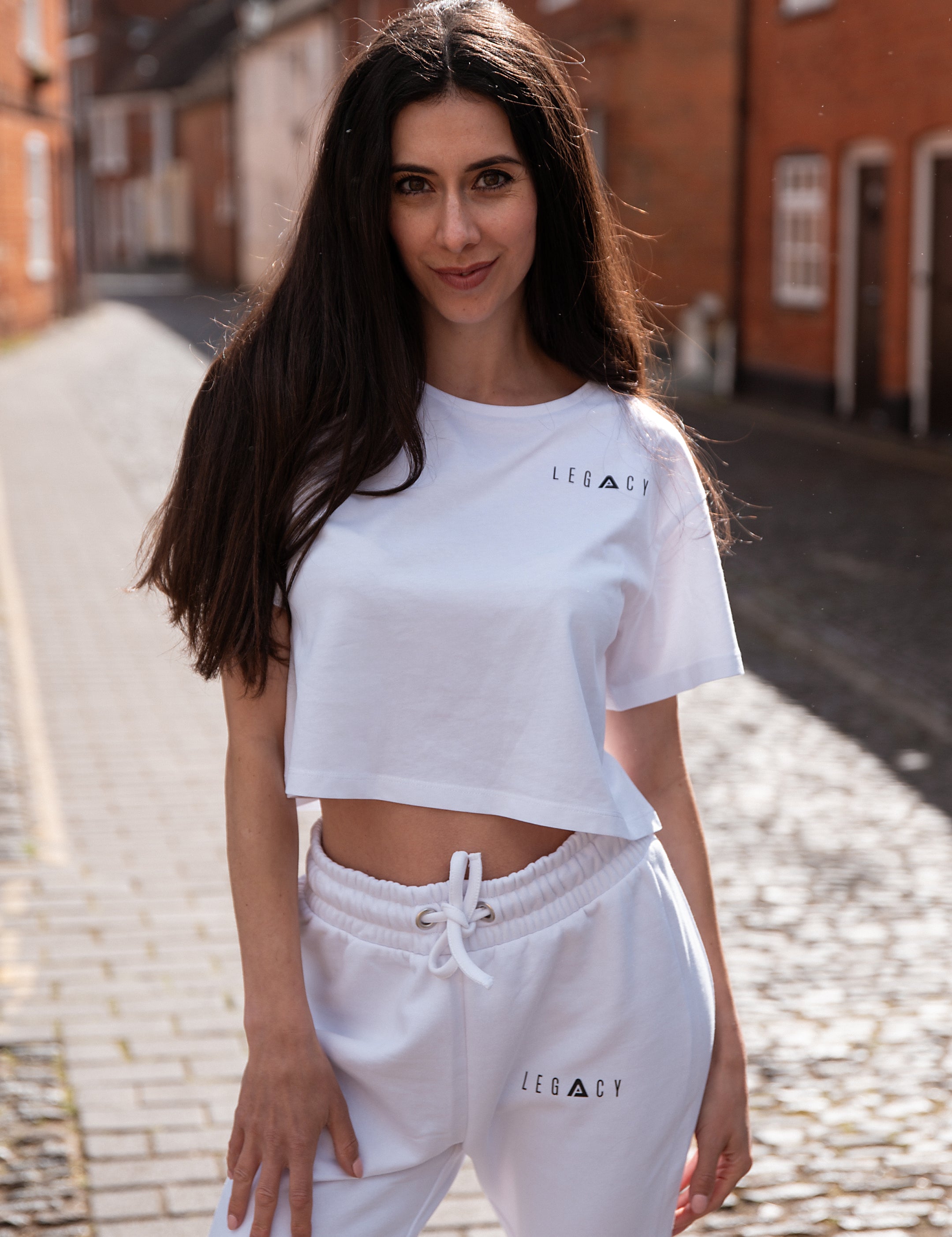 Women's white crop t-shirt with small black logo.