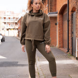 Women's olive oversized crop hoodie with tie waist and small white logo.