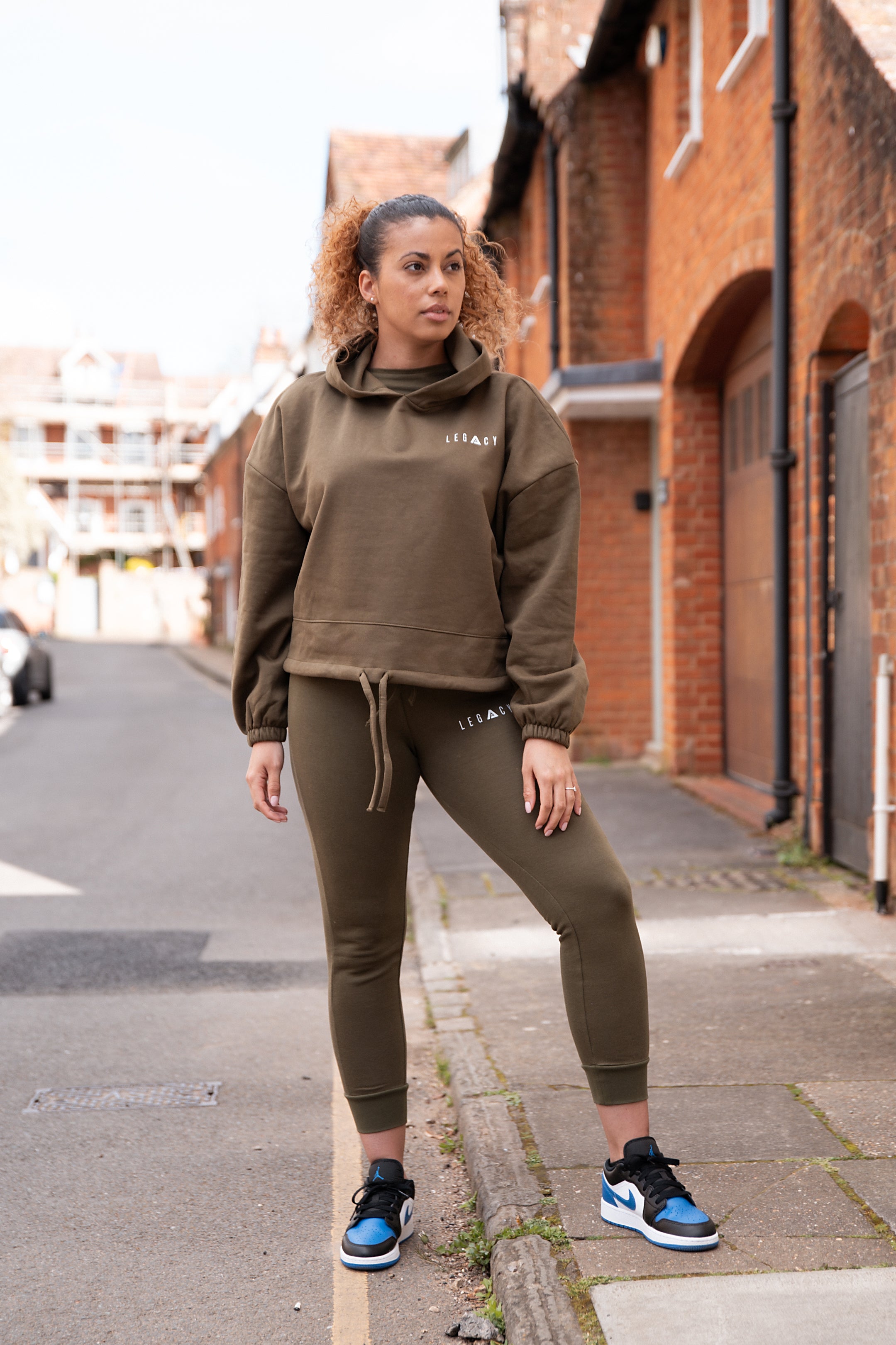 Women's olive oversized crop hoodie with tie waist and small white logo.