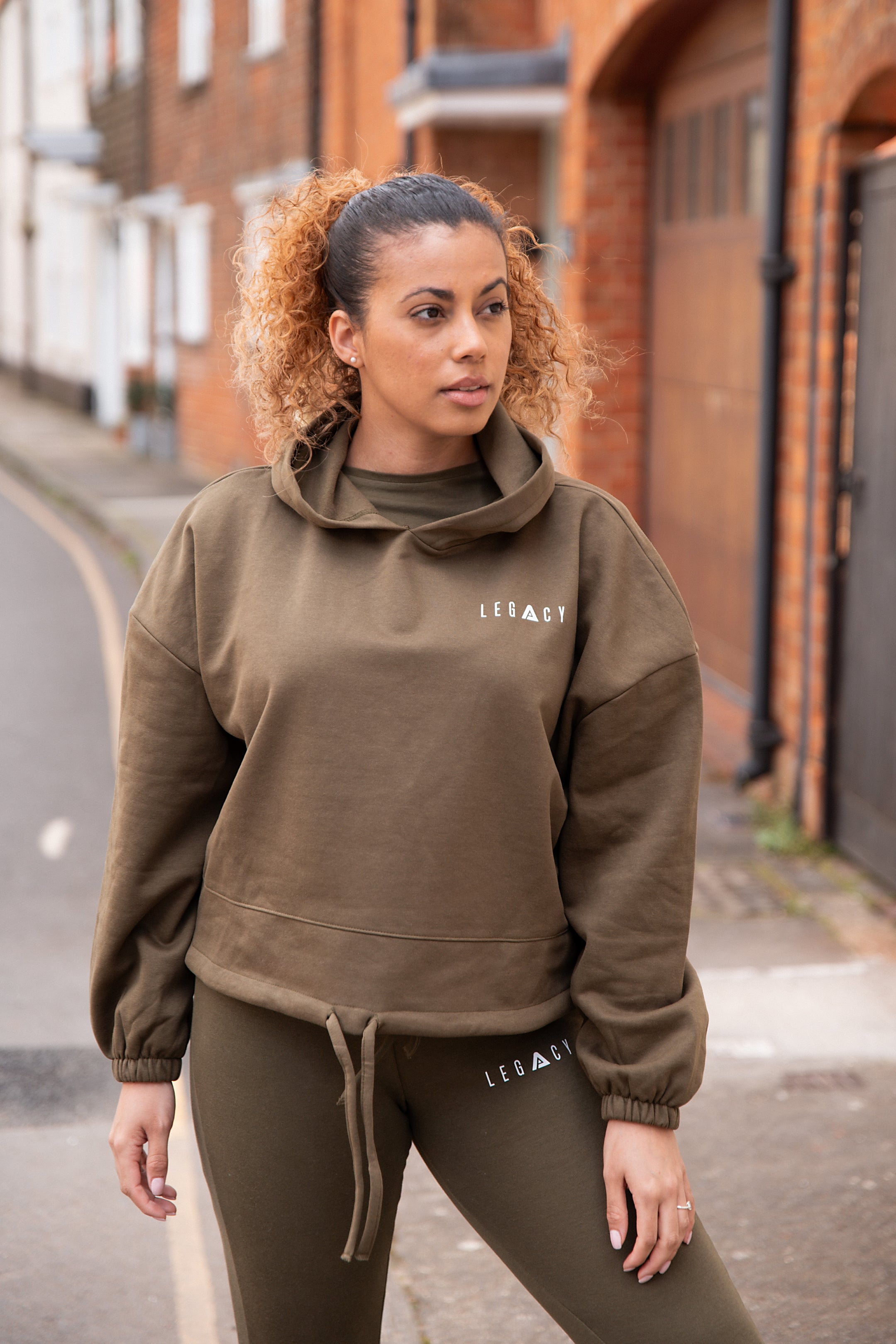 Women's olive oversized crop hoodie with tie waist and small white logo.