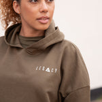 Women's olive oversized crop hoodie with tie waist and small white logo.
