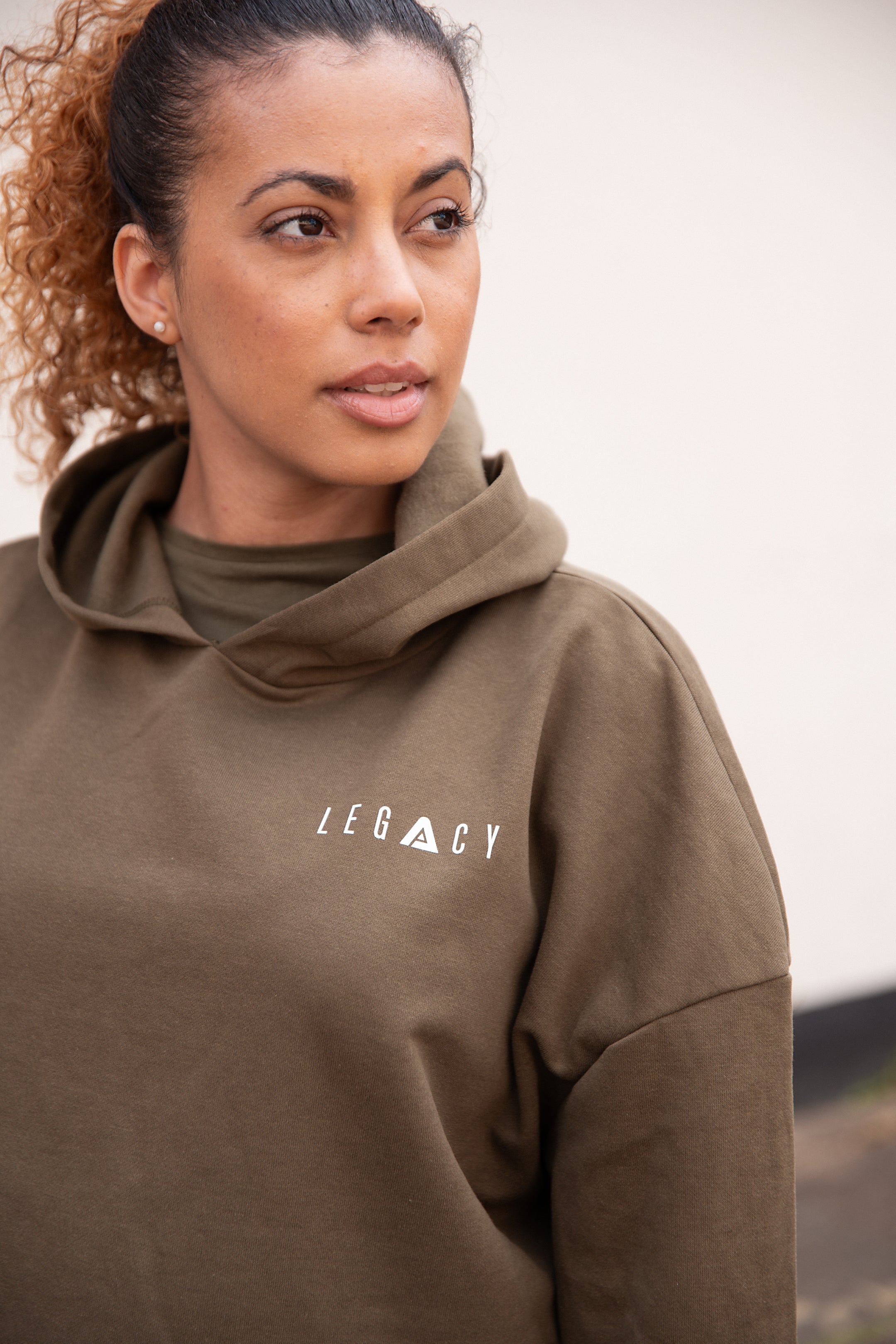 Women's olive oversized crop hoodie with tie waist and small white logo.