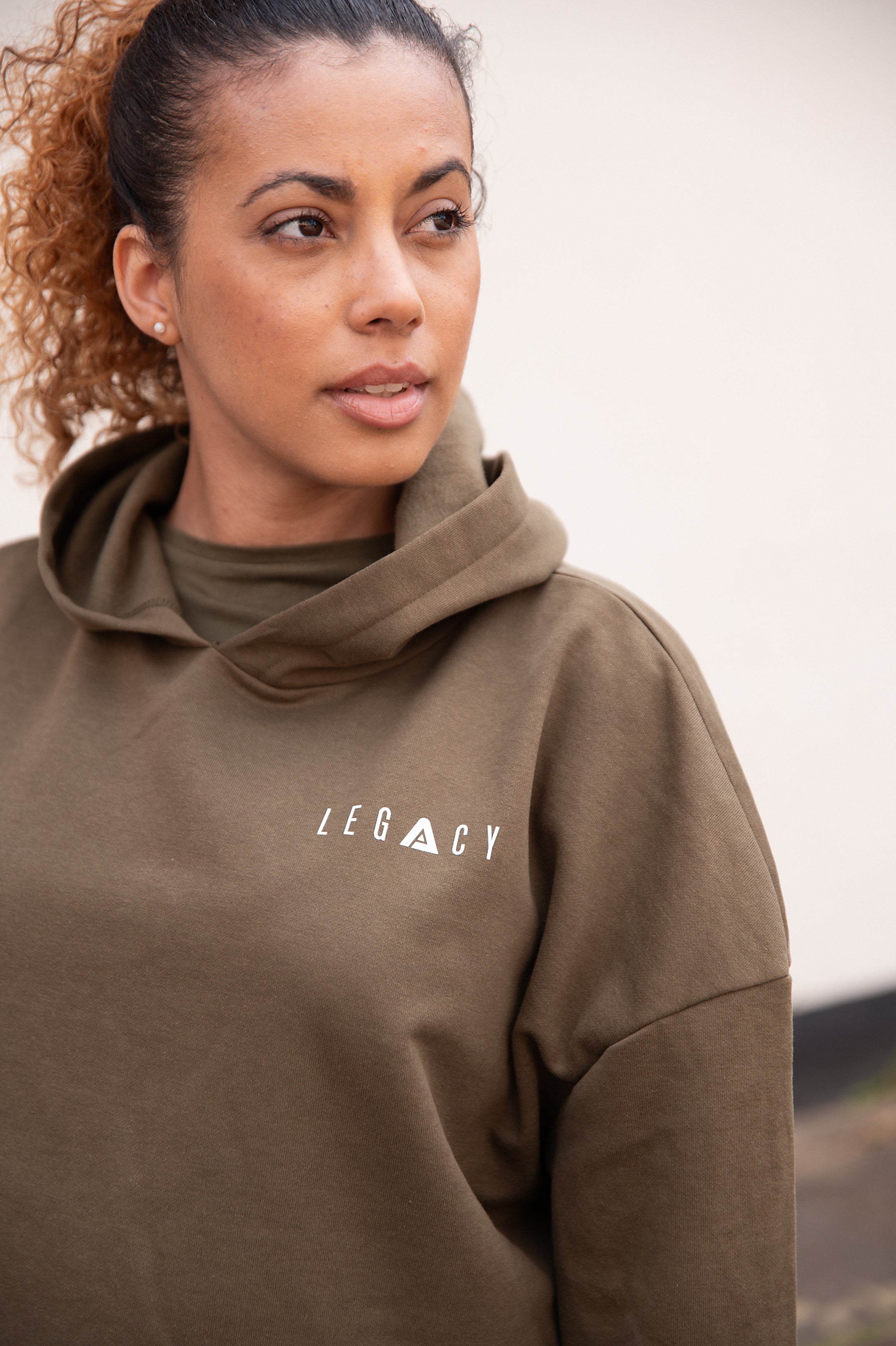 Women's olive oversized crop hoodie with tie waist and small white logo.
