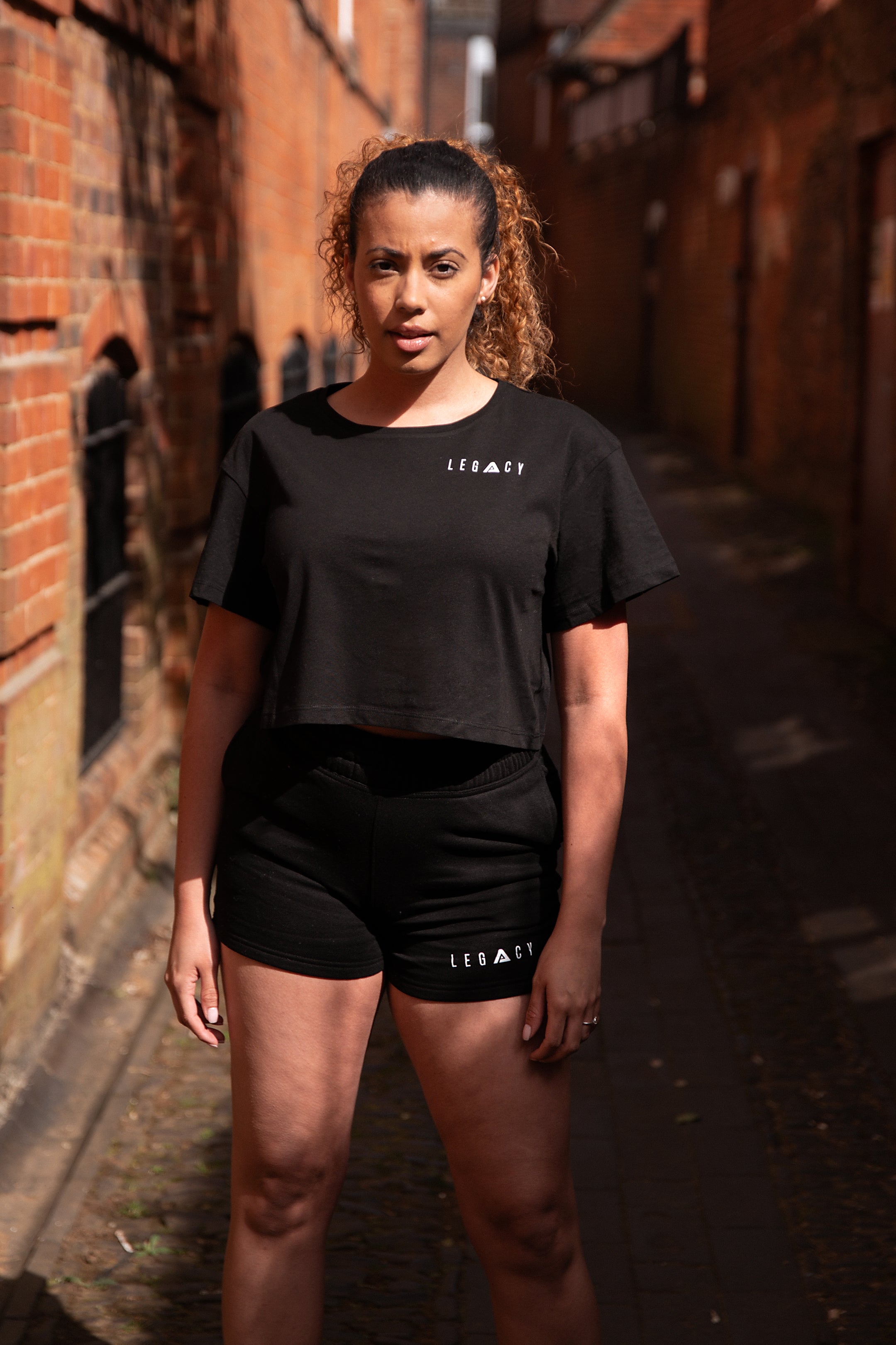 Women's black crop t-shirt with white logo.