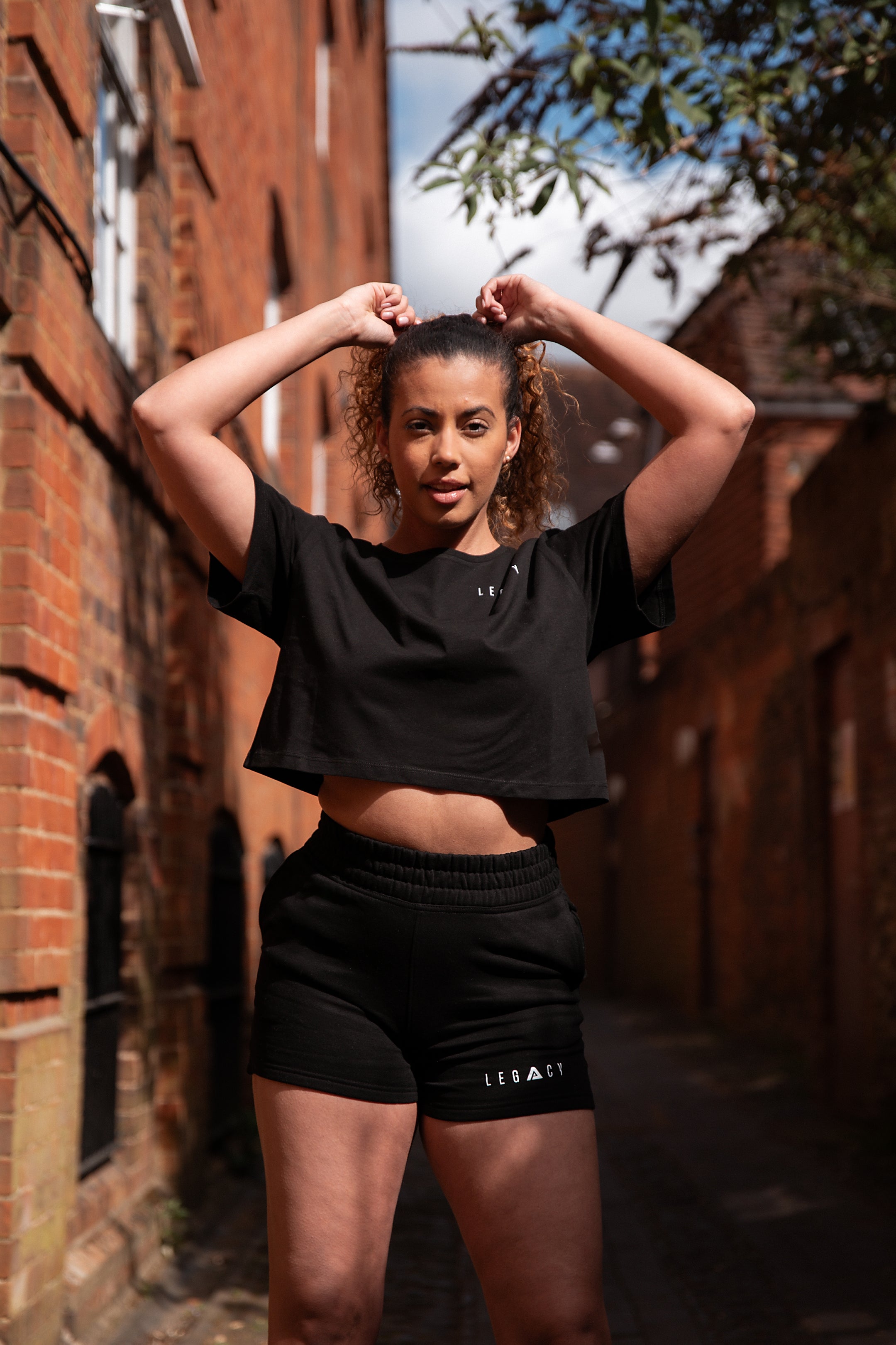 Women's black crop t-shirt with white logo.