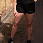Women's black shorts with small white Legacy logo on leg.